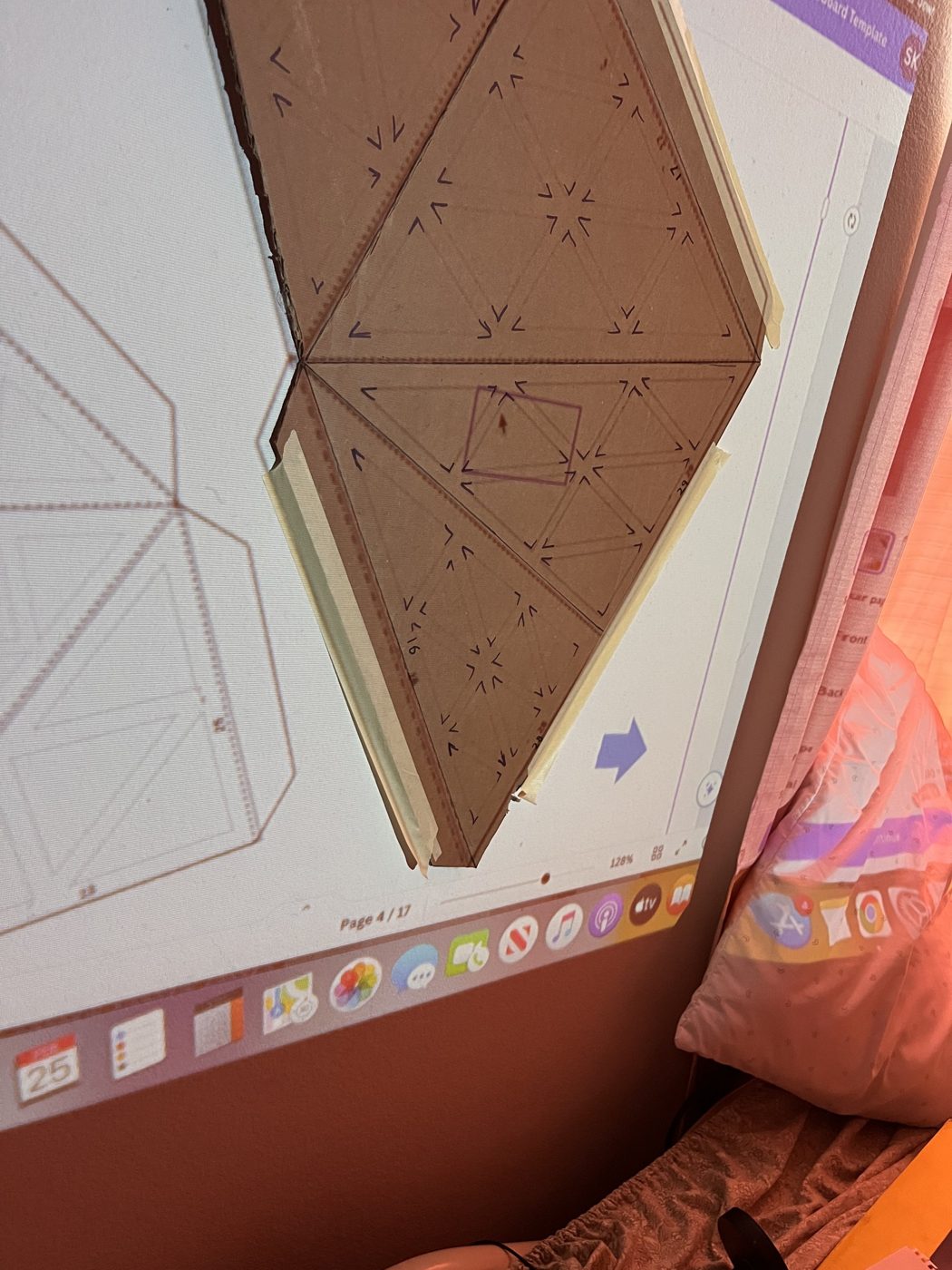 The unfold template projected onto a cardboard panel taped to the wall for full-scale tracing