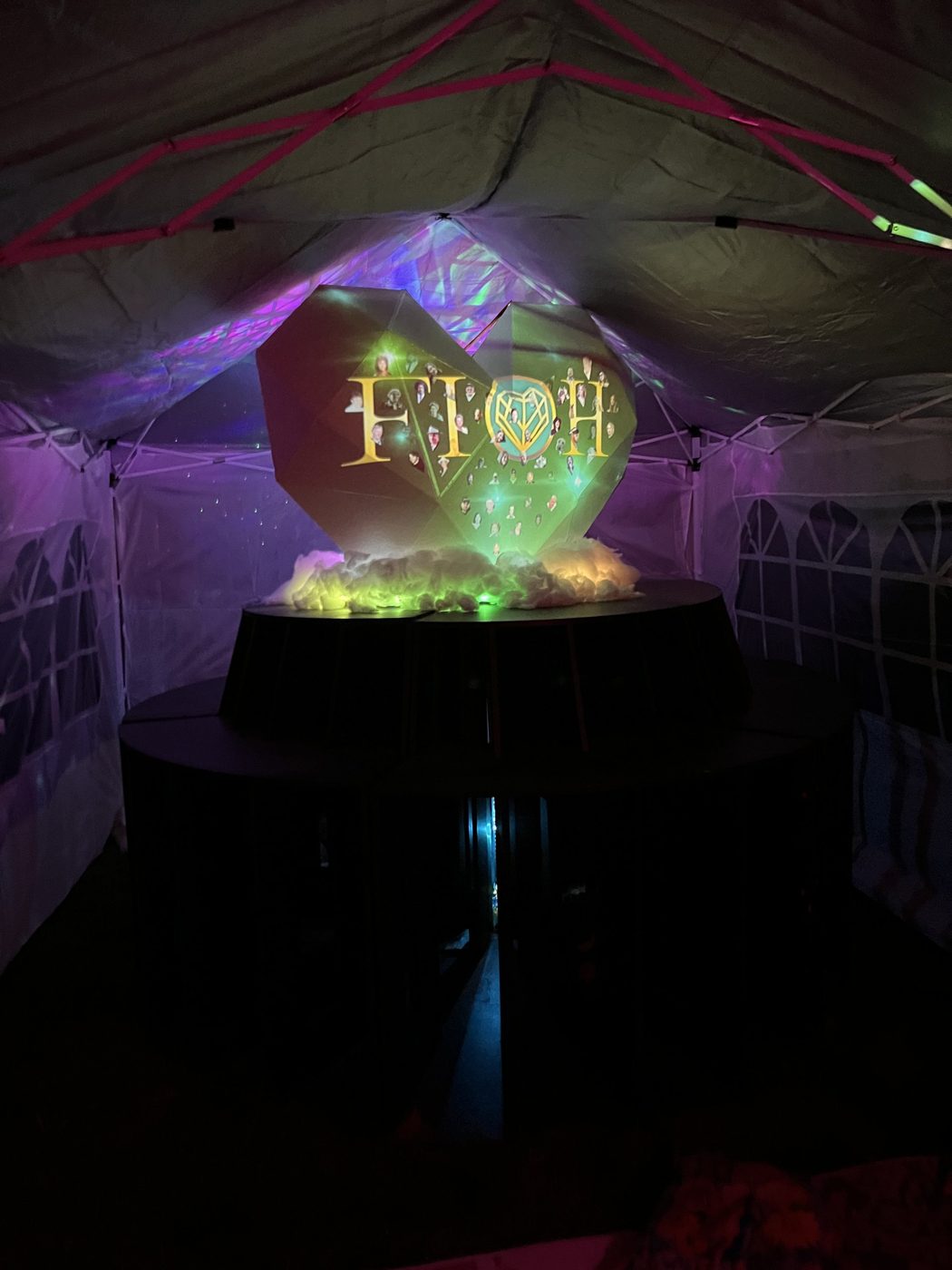 FIOH installed in its tent at SNRG, logo and portraits projected