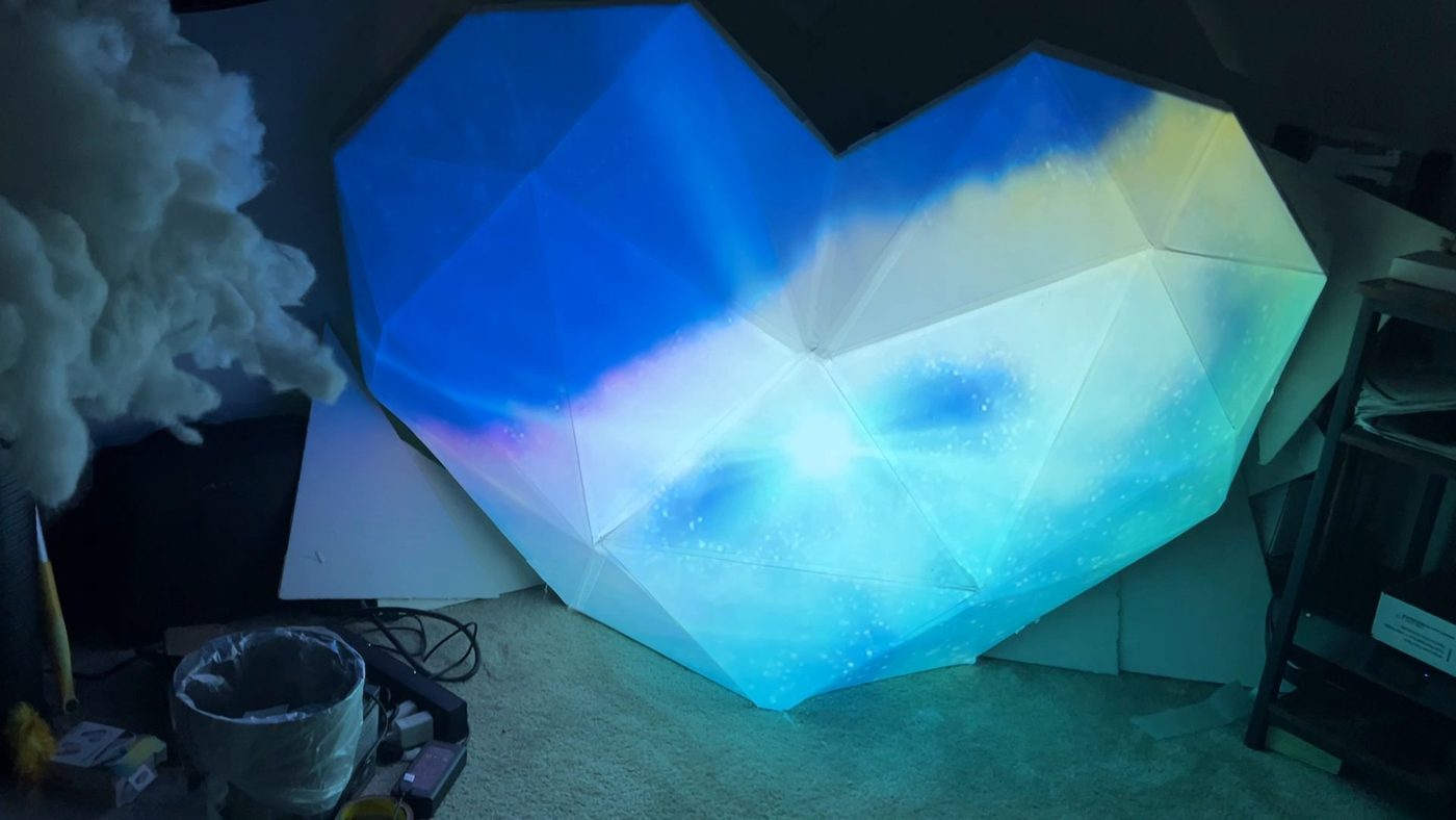 The corrugated plastic v1 heart glowing with projection-mapped blue clouds