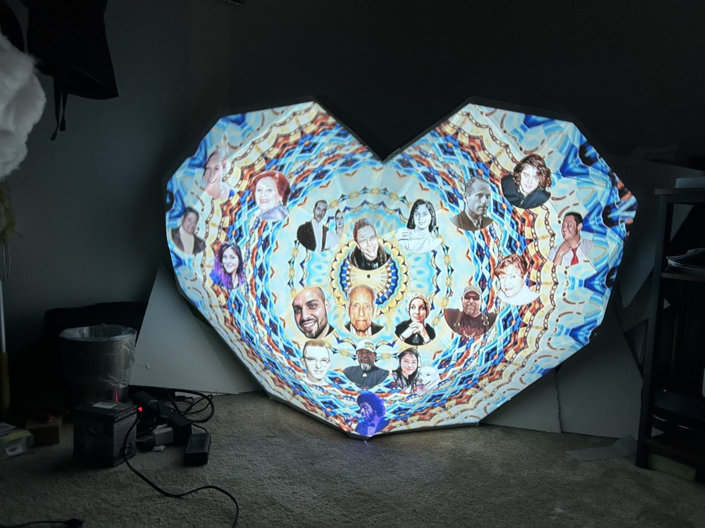 Portraits woven into a kaleidoscopic pattern projected across the v1 heart